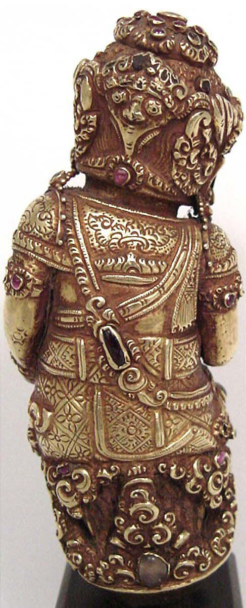 Dagger handle, Engraved and chased sheet gold, inset with semiprecious stones and rock
crystal, over wood, Indonesia (Bali or Eastern Java)