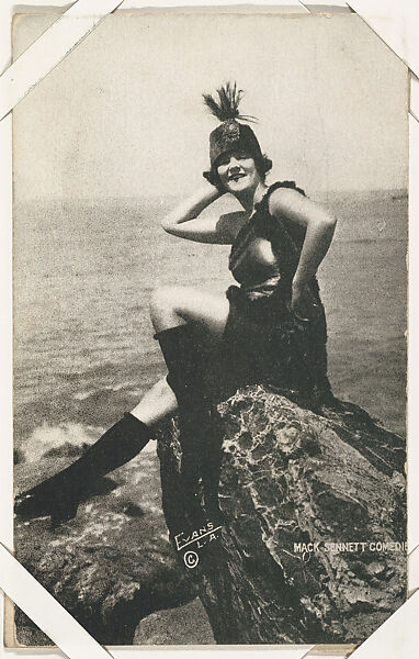 Bathing beauty in costume with boots, seated on rock from Mack Sennett Comedies Arcade series (W423), Commercial photolithograph 