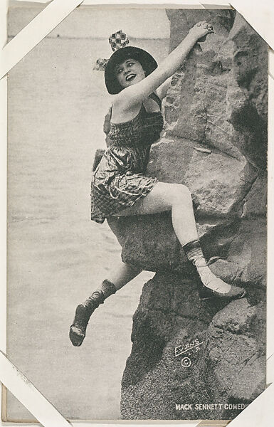 Bathing beauty in costume posed climbing rock from Mack Sennett Comedies Arcade series (W423), Commercial photolithograph 