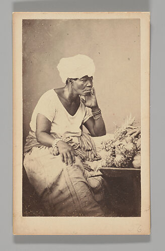 [Studio Portrait: Female Street Vendor Seated Wearing Turban, Brazil]
