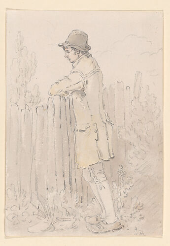 A young man leaning on a fence