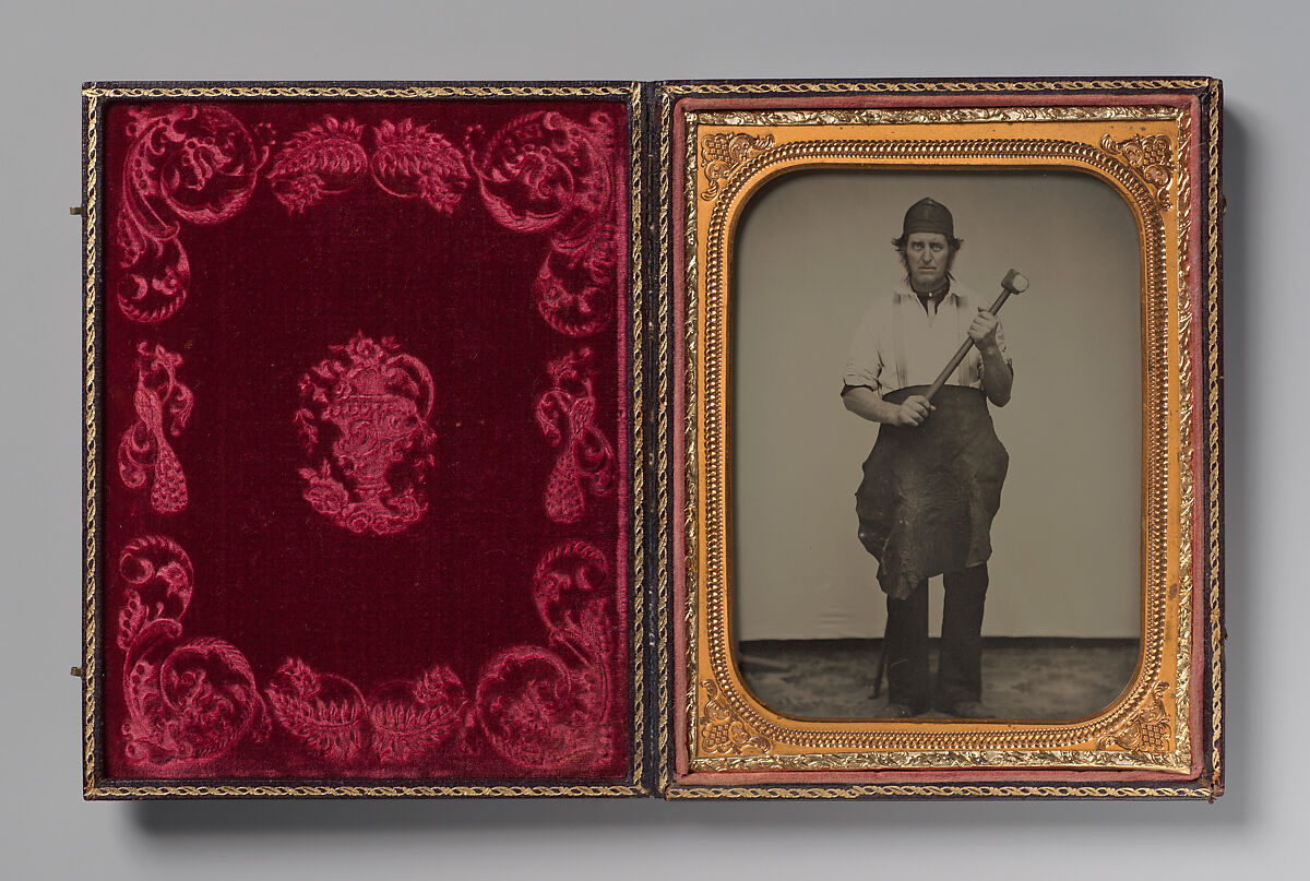 [Man Gripping Sledgehammer, Wearing Leather Half Apron and Cap], Unknown, Ambrotype with applied color