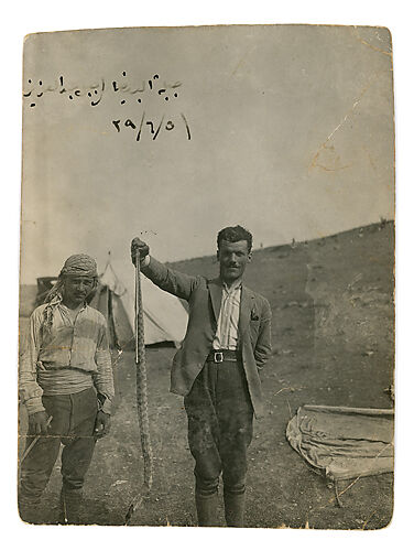 Photograph of Faik Borkhoche holding a snake at Tell Halaf
