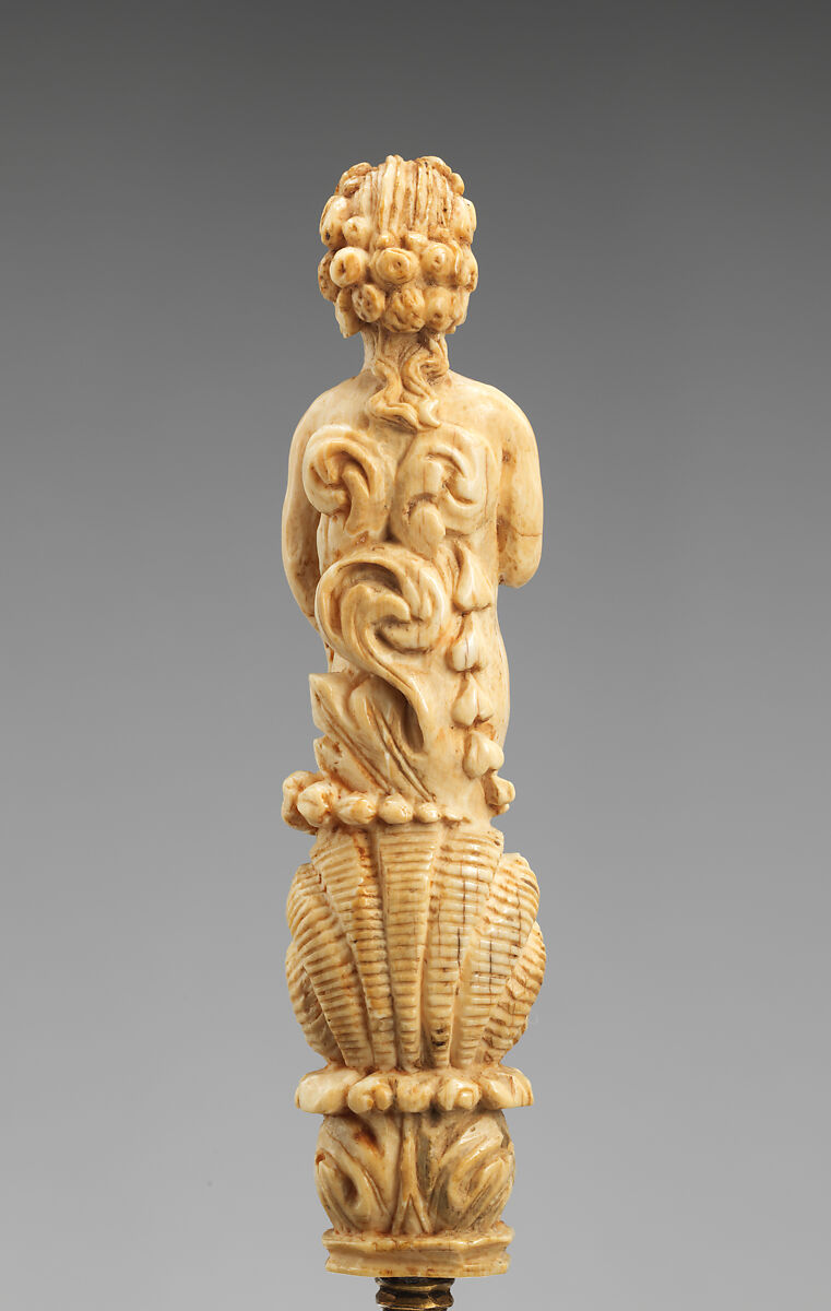 Paper knife with carved handle of nude with sun in hair standing in a half shell holding a swag, Steel gilt, ivory, Italian