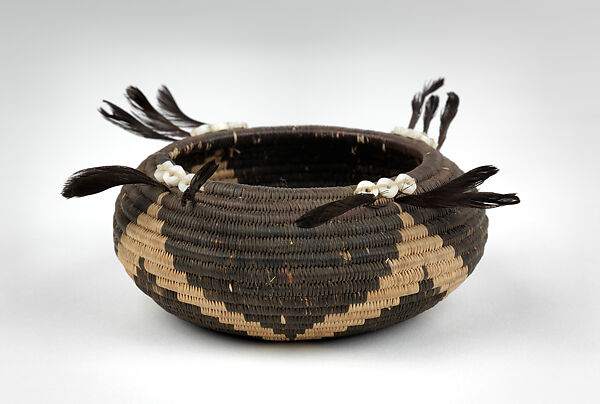 Three-rod coiled negative basket, Willow shoot foundation, sedge root weft, dyed bulrush root weft, feathers (California valley quail topknots), clamshell disk beads, and cotton string, Big Valley Pomo (Lake County, California) 
