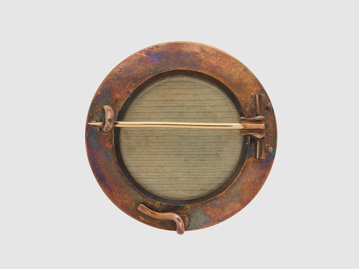 Brooch with Assyrian divine archer in a winged disc, Gold, glass, British