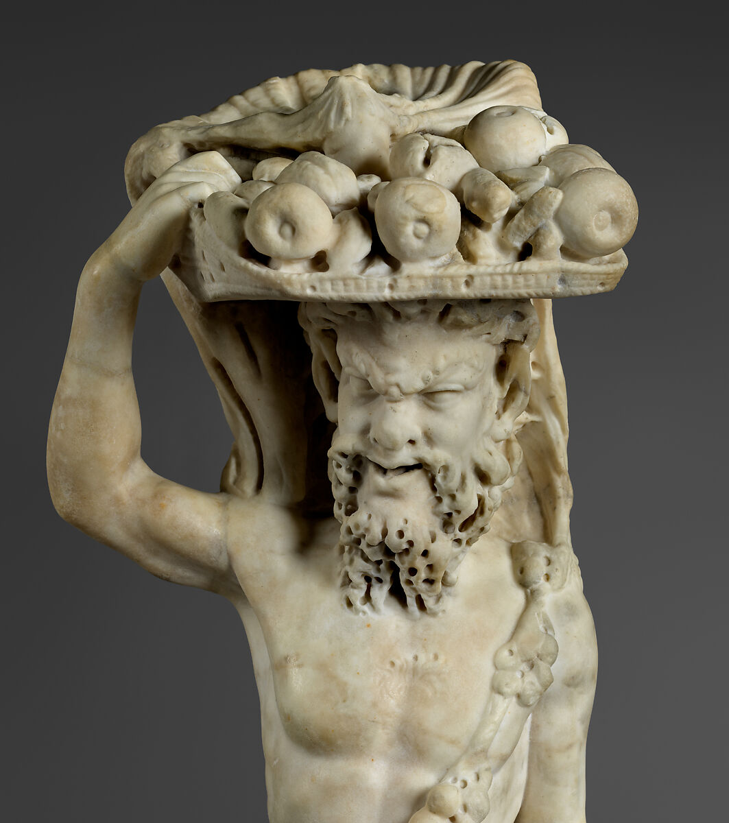 Marble statue of Pan/ Pan or Satyr with winnowing basket filled with offerings and cultic objects, Marble